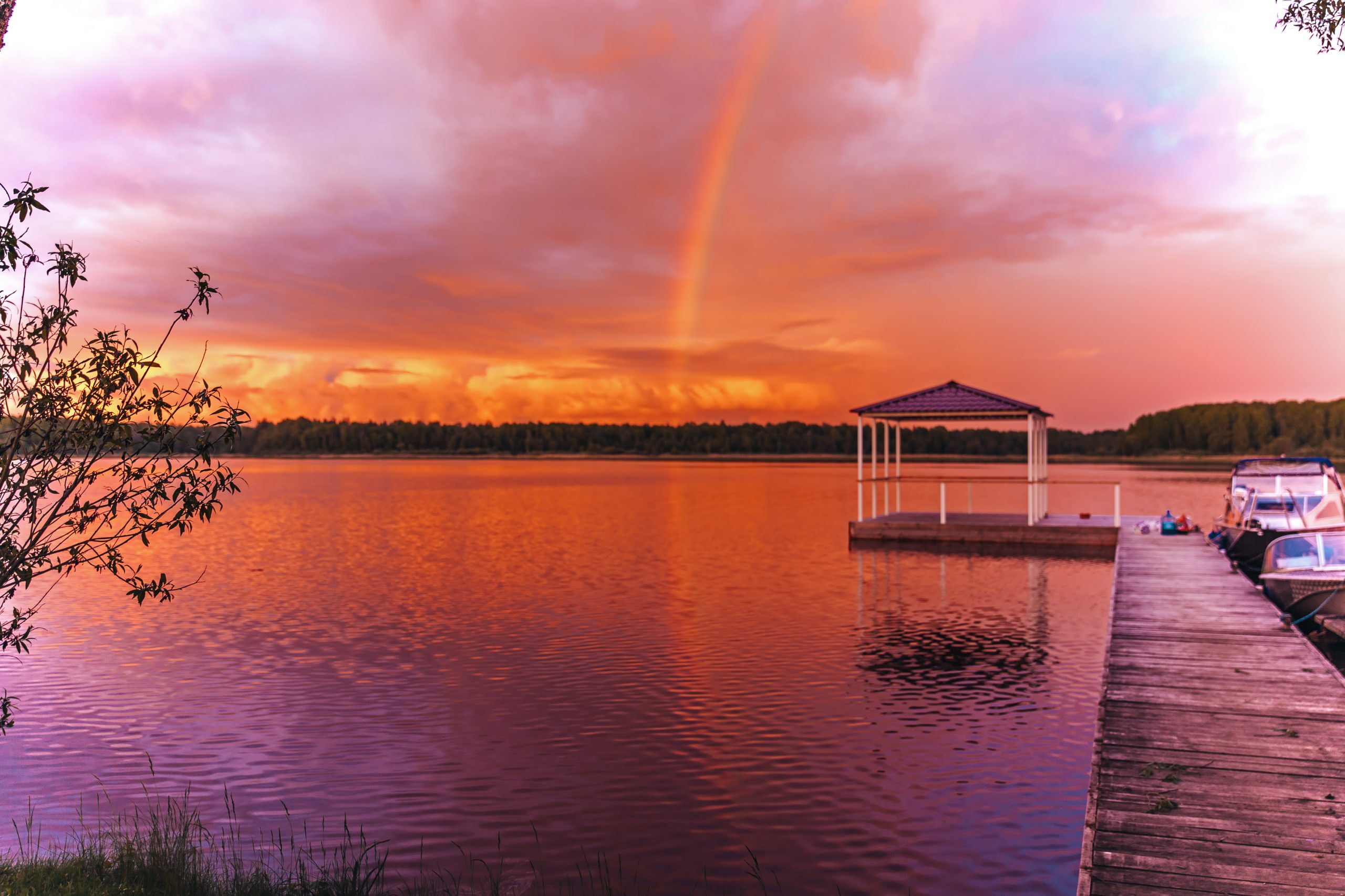 Scenic view of the sunset sunset on the river and rainbow a gazebo on the water